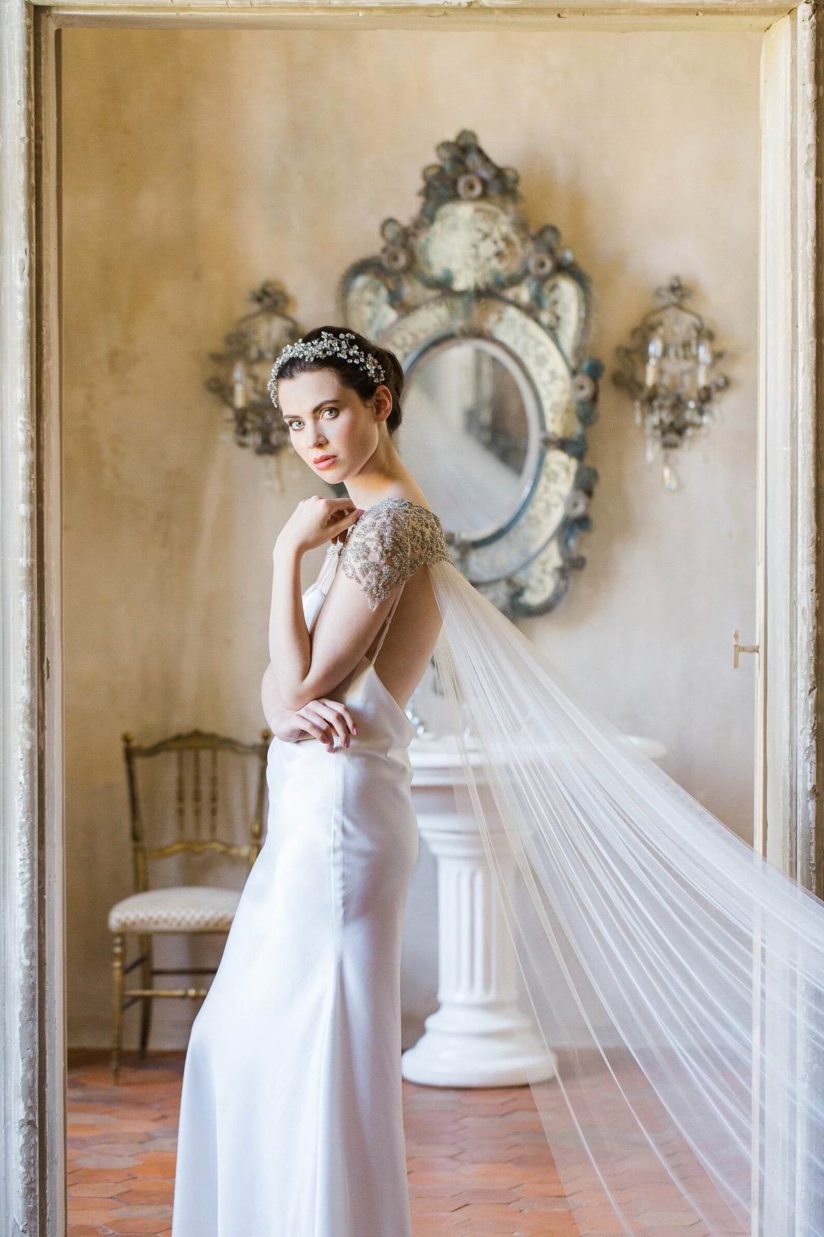Damaris couture-bruidscape van Hanna Peters × Gibson Bespoke met handgeborduurde kristallen in geometrische patronen, een verfijnde schouderlijn en een zachte, vloeiende tule sleep.