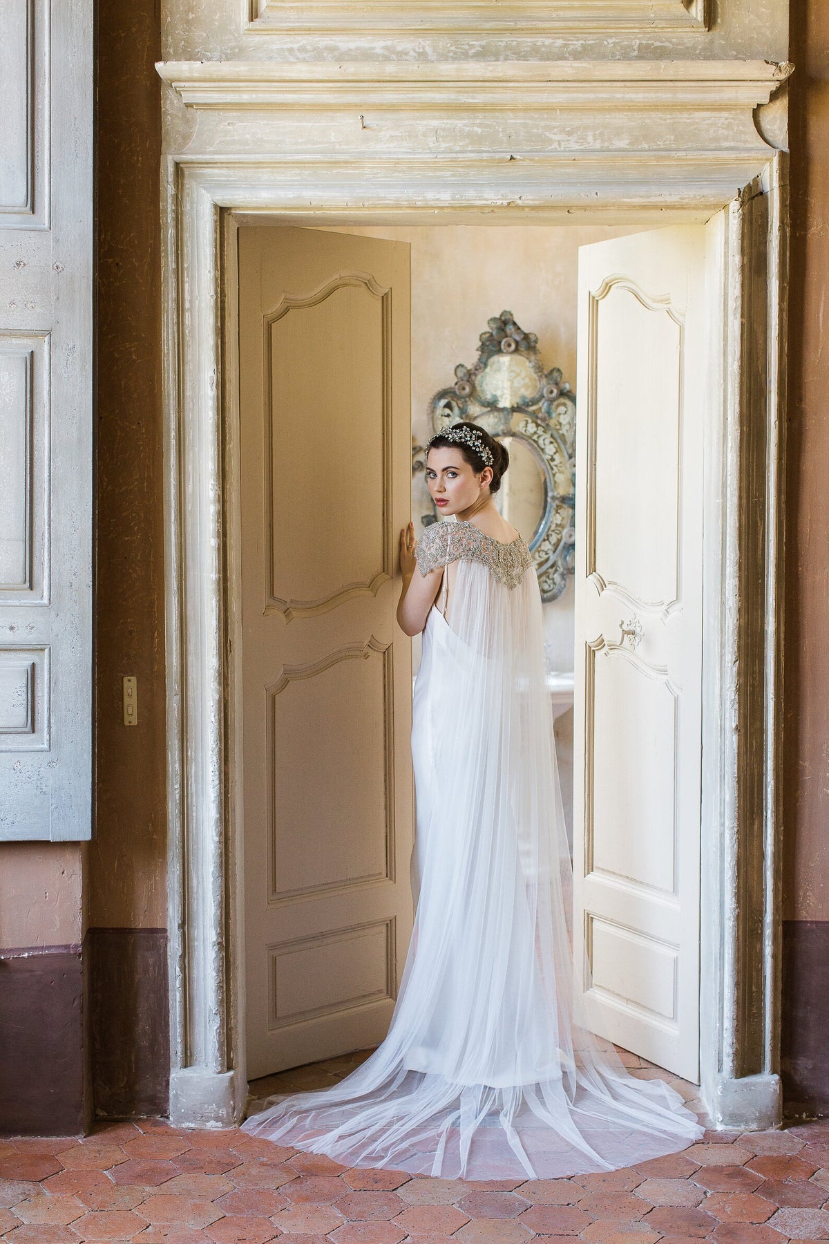 Damaris couture-bruidscape van Hanna Peters × Gibson Bespoke met handgeborduurde kristallen in geometrische patronen, een verfijnde schouderlijn en een zachte, vloeiende tule sleep.