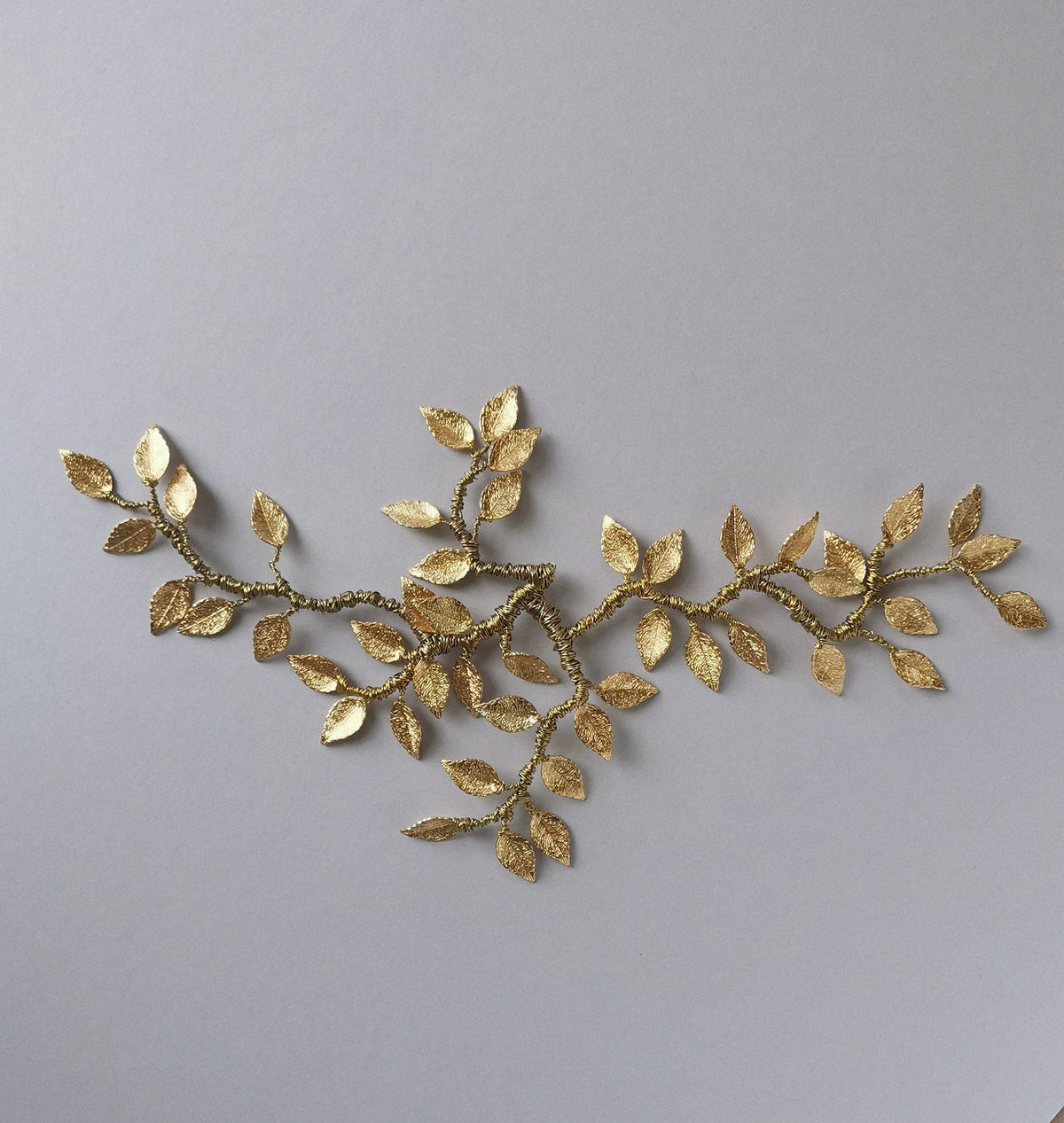 De Rijen gouden botanische bruids haarrank van Hanna Peters × Gibson Bespoke met handgevormde gouden wijnbladeren, flexibele takken en een verfijnde antieke afwerking.