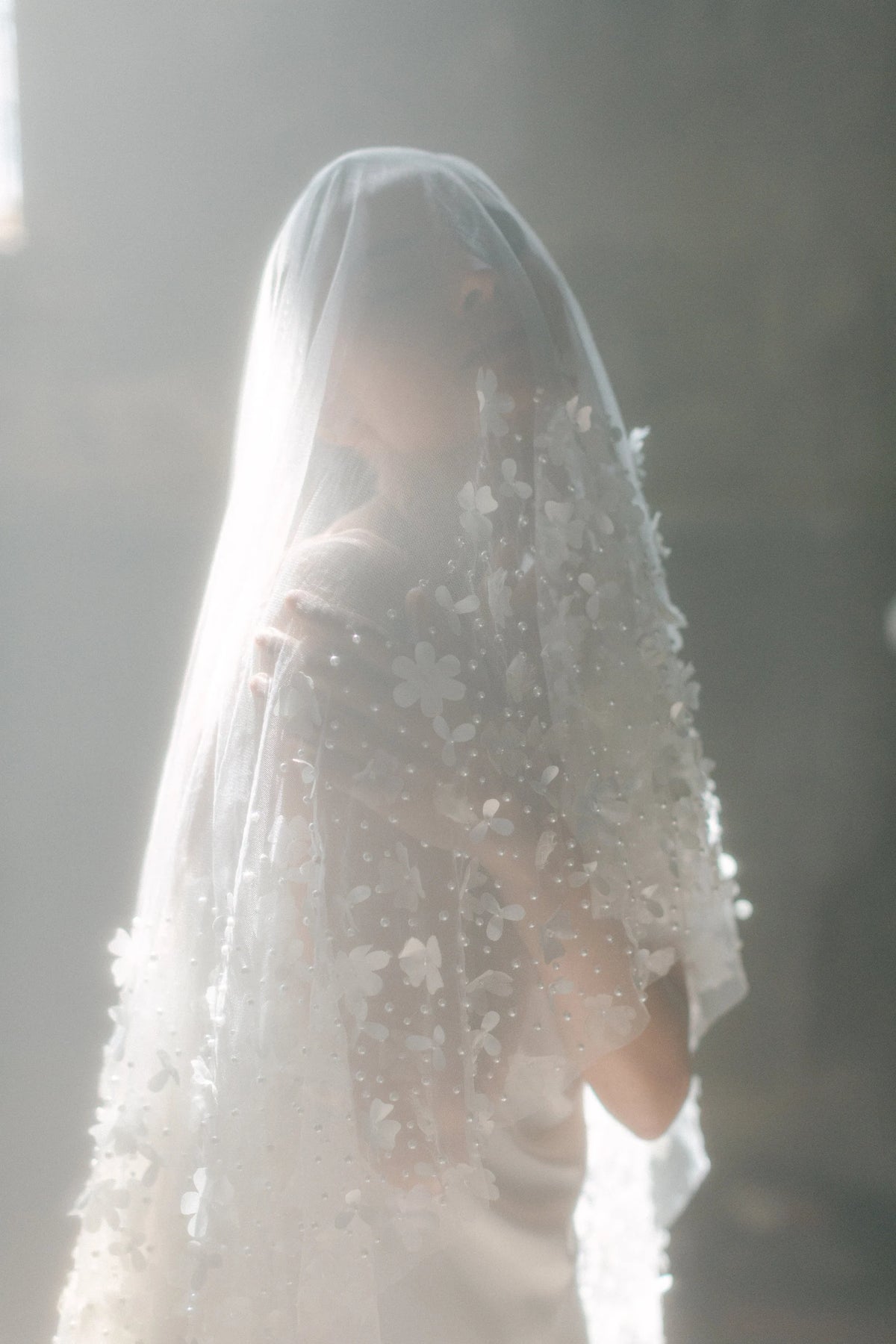 Seraphine romantische bruidssluier van Hanna Peters × Gibson Bespoke met handgemaakte bloemen van zijdesatijn, zijdechiffon en tule, verspreide glasparels en een lange sleep.
