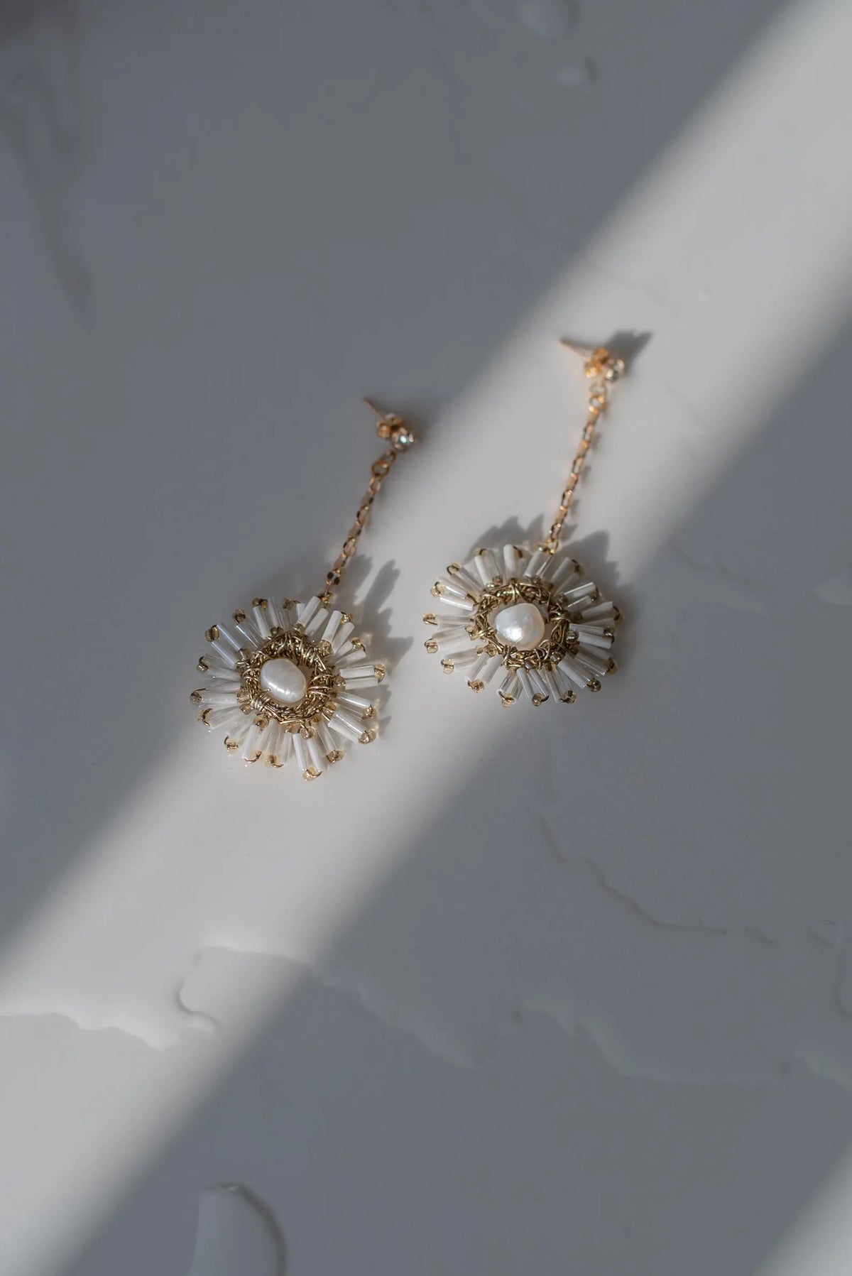 Leeuw statement bruidsoorbellen van Hanna Peters × Gibson Bespoke met stervormige ivoor- en goudkleurige glaskralen en vergulde ketting