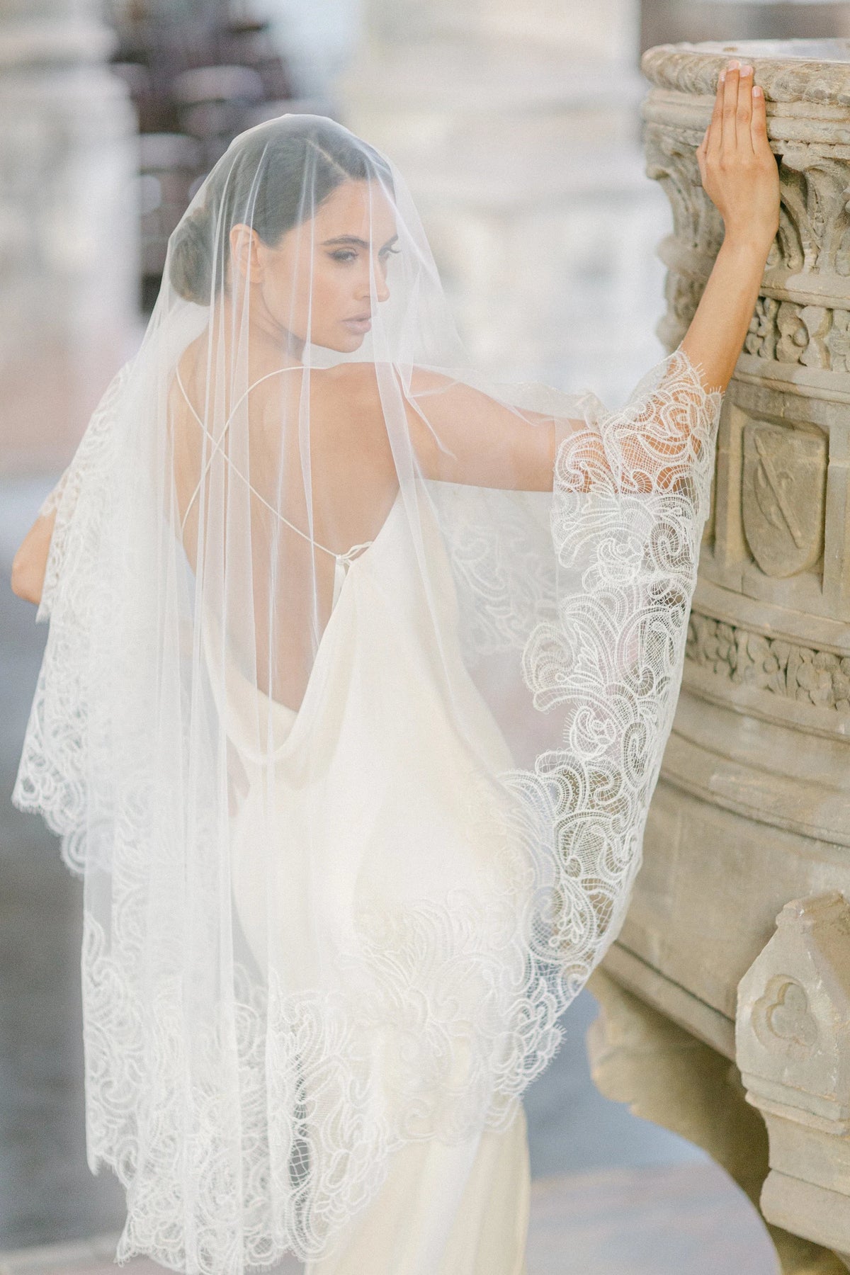 Ambra ivoorkleurige bruidssluier van Hanna Peters × Gibson Bespoke, met handgestikt Italiaans kant, abstract gebogen kantmotief, fijne wimperranden en transparante Italiaanse tule.