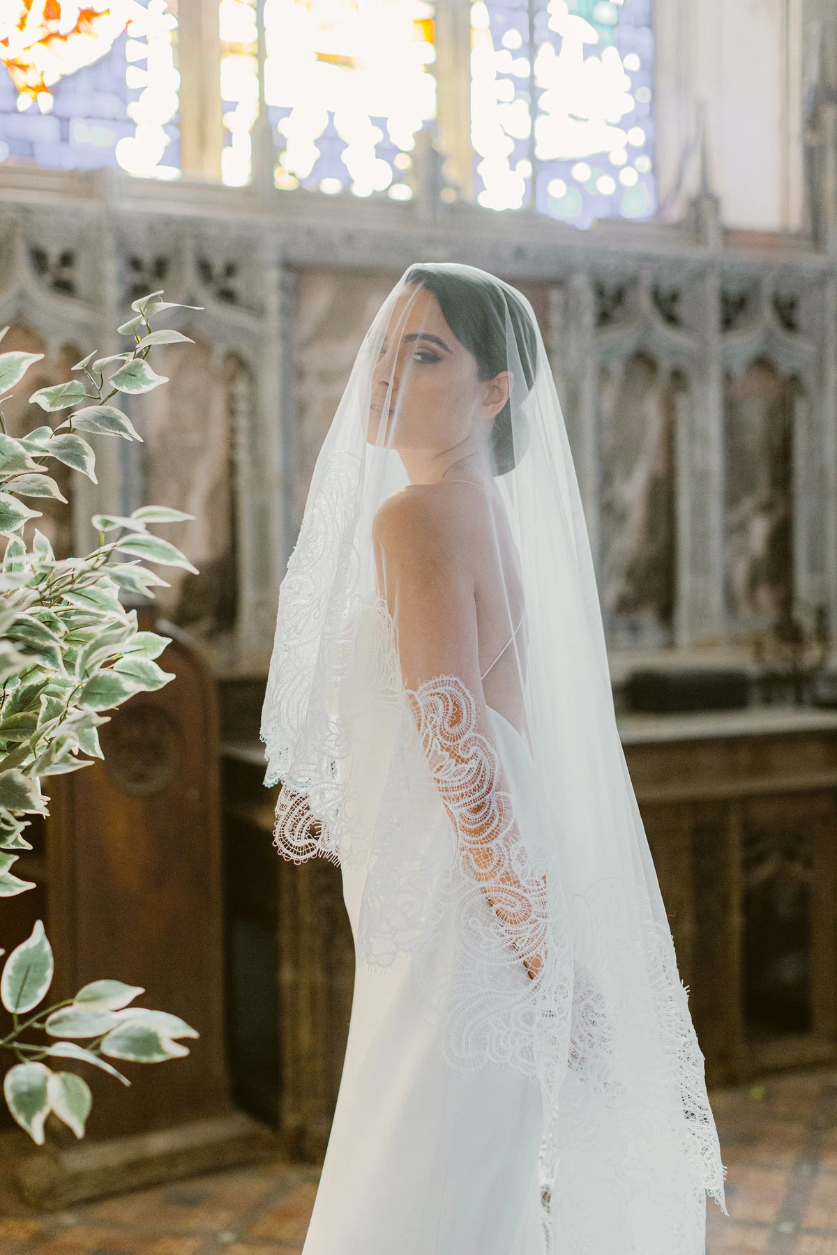 Ambra ivoorkleurige bruidssluier van Hanna Peters × Gibson Bespoke, met handgestikt Italiaans kant, abstract gebogen kantmotief, fijne wimperranden en transparante Italiaanse tule.
