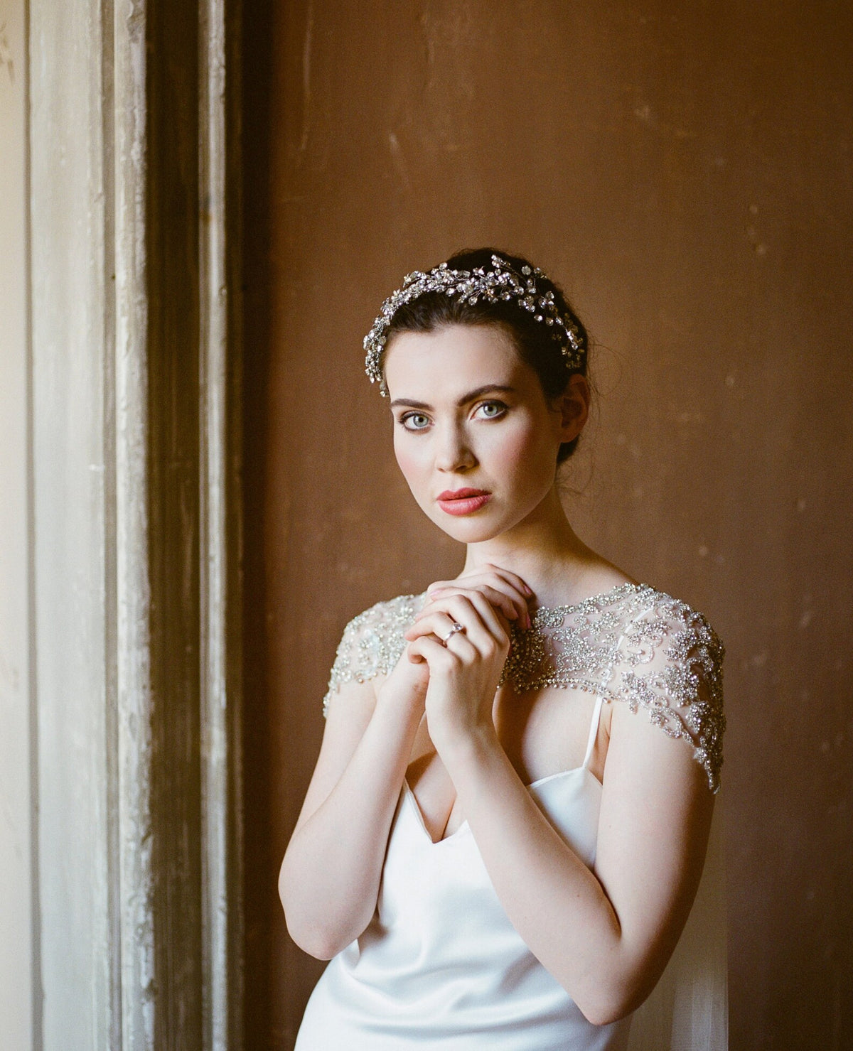 Damaris couture-bruidscape van Hanna Peters × Gibson Bespoke met handgeborduurde kristallen in geometrische patronen, een verfijnde schouderlijn en een zachte, vloeiende tule sleep.