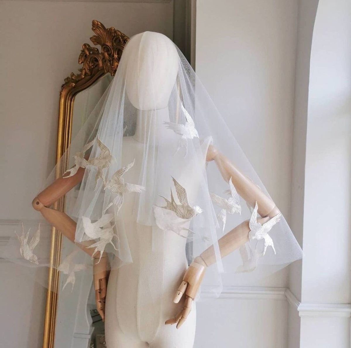 Passerine ivoorkleurige bruidssluier van Hanna Peters × Gibson Bespoke, gemaakt van transparante Italiaanse tule met handgenaaide zwaluwen van zuivere zijde en een cirkelvormige watervalvalling.