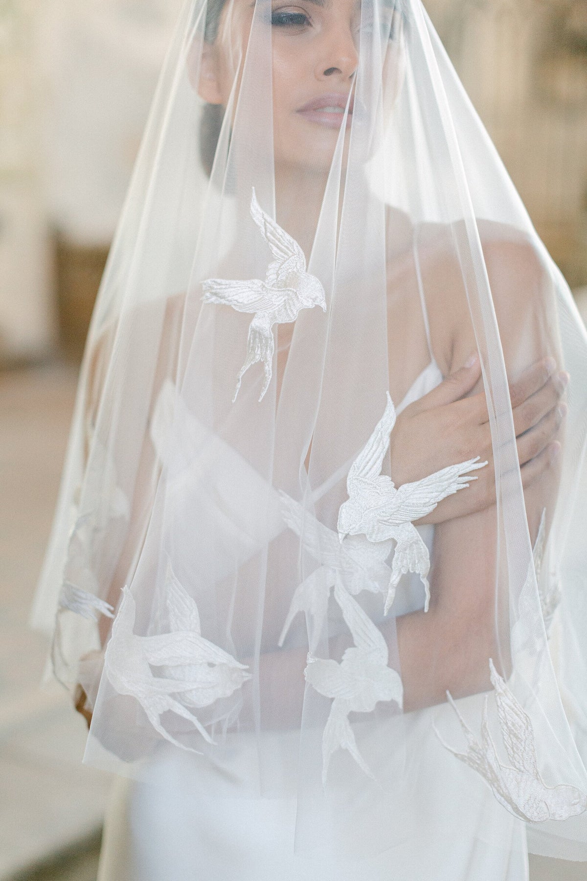 Passerine ivoorkleurige bruidssluier van Hanna Peters × Gibson Bespoke, gemaakt van transparante Italiaanse tule met handgenaaide zwaluwen van zuivere zijde en een cirkelvormige watervalvalling.