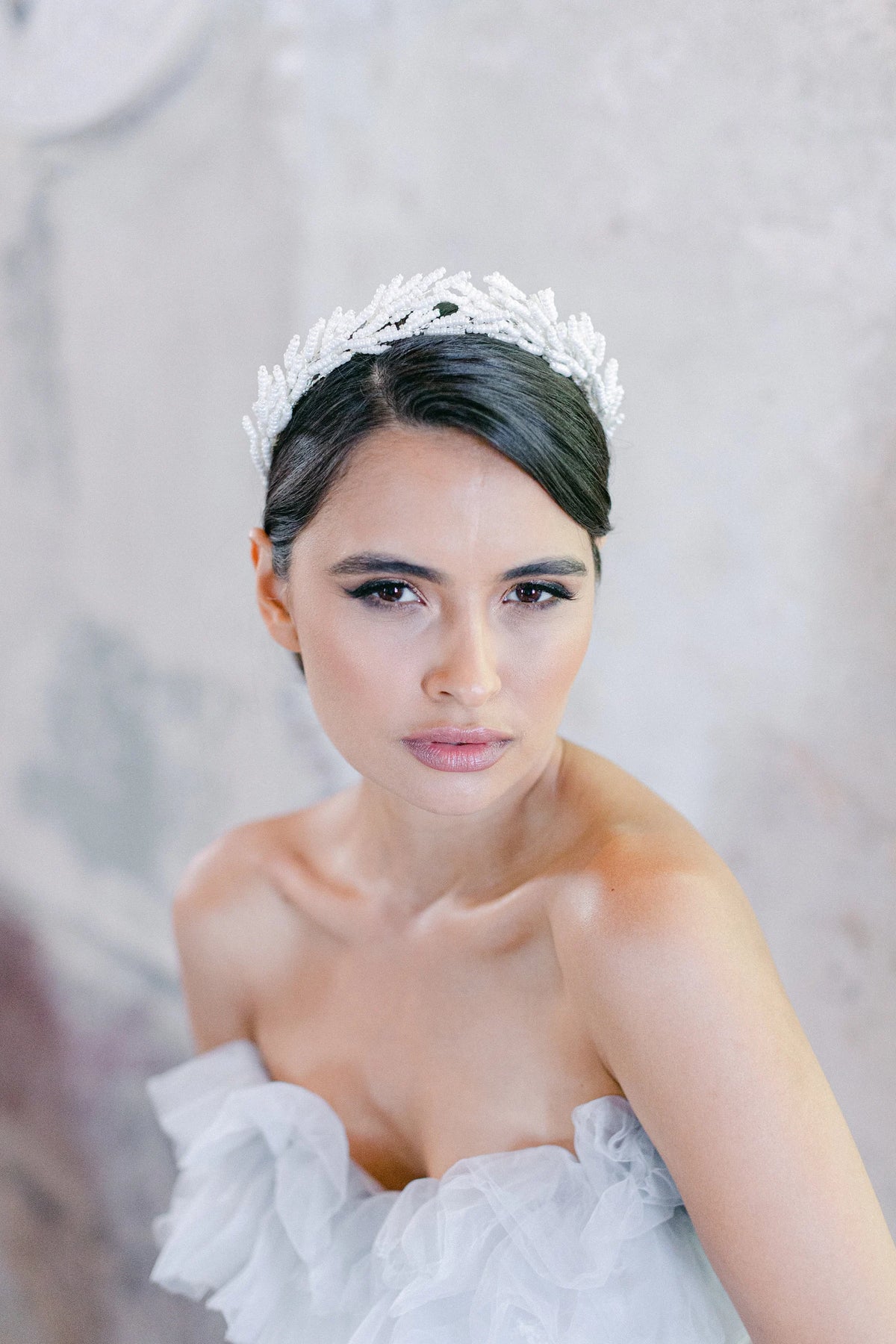 Weidezoet elegante bruidskroon van Hanna Peters × Gibson Bespoke met handgemaakte botanische takken van glanzende ivoorkleurige glaskralen in een verfijnde Griekse stijl.